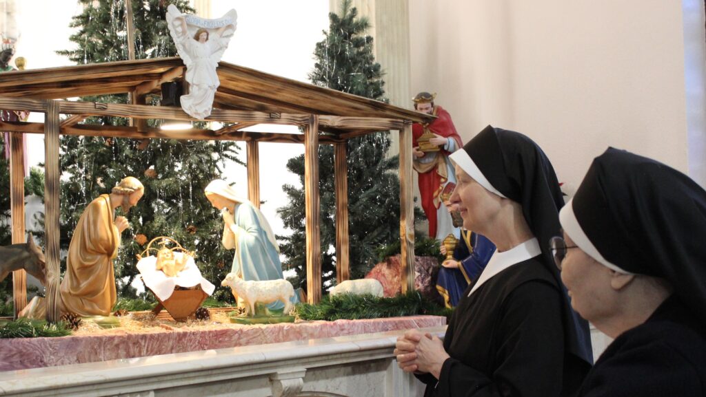 Two sisters looking at a nativity scene