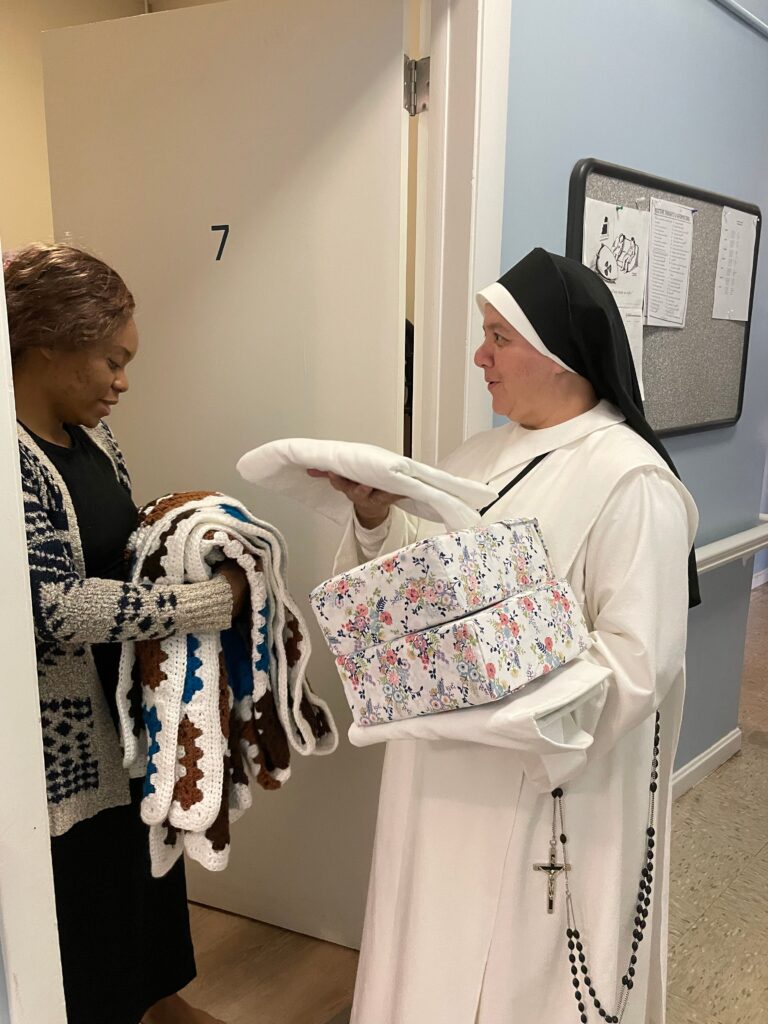 Sister delivering blanket to a woman